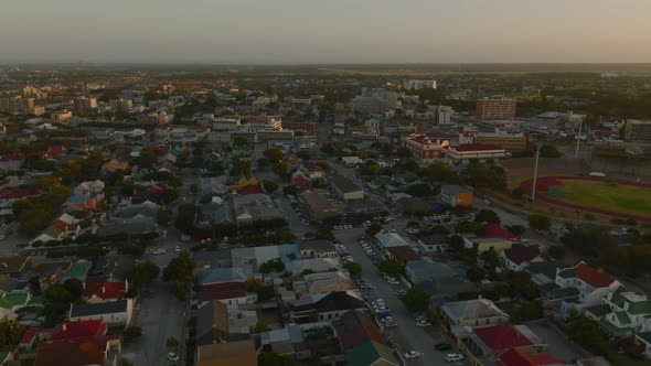 Aerial Descending Footage of Buildings in Town at Dusk alt