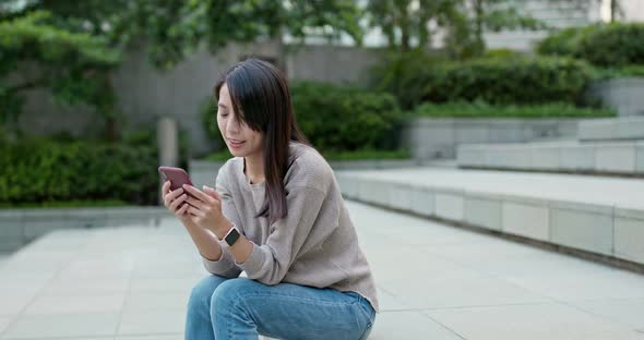 Woman use of mobile phone and sit on the floor alt