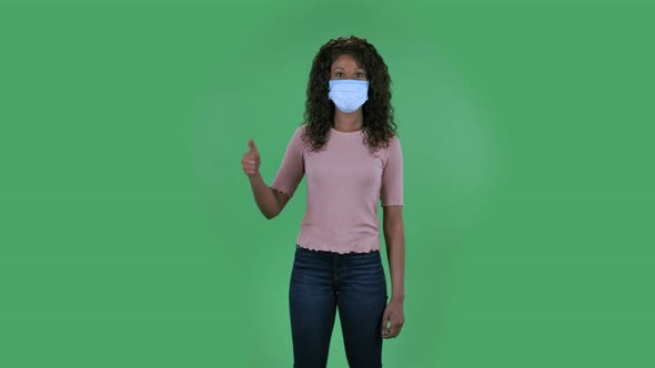 Portrait of Beautiful African American Young Woman in Medical Protective Face Mask Looking at Camera alt
