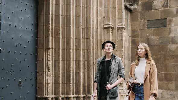 Beautiful and Style Friends Walking with Map and Camera Through the Street alt