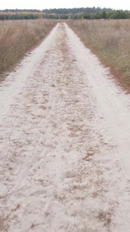 Vertical Video a Dirt Road Through an Empty Field alt