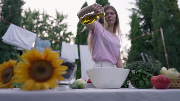 Cooking Oil Pouring in Slow Motion in White Bowl Outdoors on Summer Spring Day alt