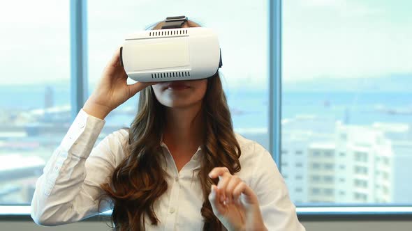 Female executive using virtual reality headset alt