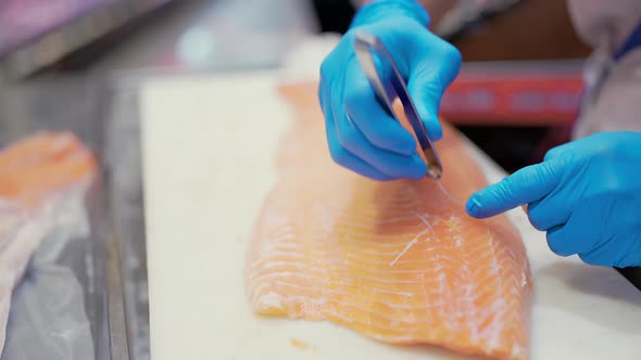 Close up to Hand of professional asian checf or fishermen preparing fresh salmon fish alt