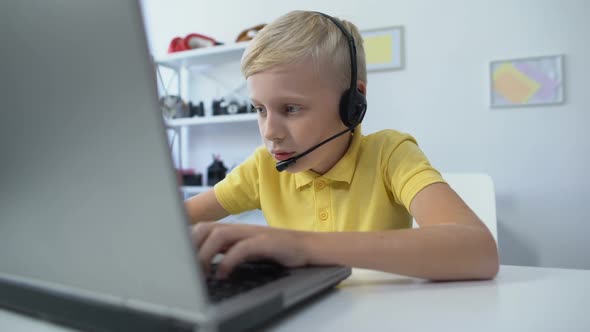 Addicted Male Kid in Headset Playing Game on Laptop Computer Modern Technologies