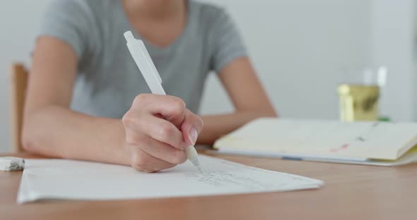 Woman take note on paper at home alt