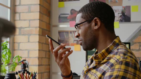 Businessman talking on mobile phone at desk 4k