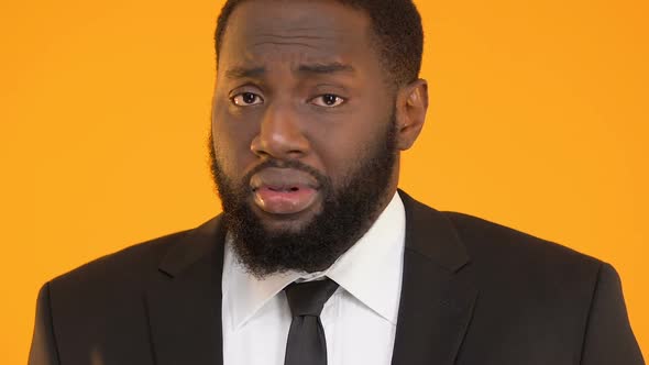 Afro-American Business Man Shrugging Shoulders, Feeling Guilty About Failed Task alt