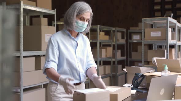 Female Manager and Courier Wearing Face Masks Working in Warehouse alt