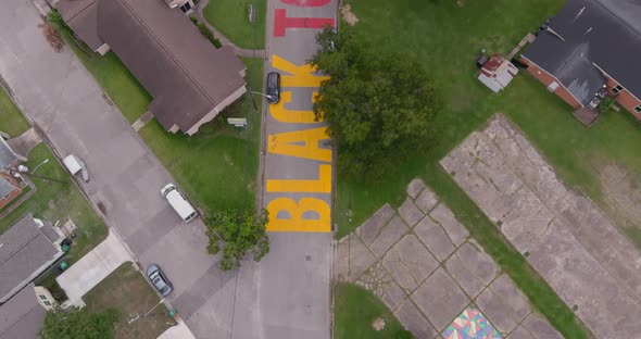 Bird eye view of a large "Black Towns Matter" sign painted on street in Houston Historical independe alt