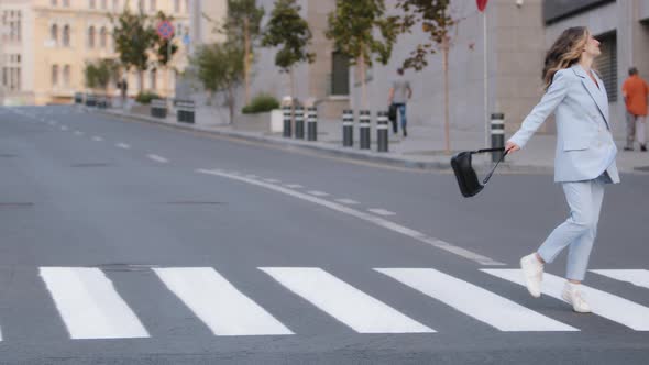 Young Beautiful Girl Model Business Woman Student in Stylish Blue Suit with Black Handbag Walking alt