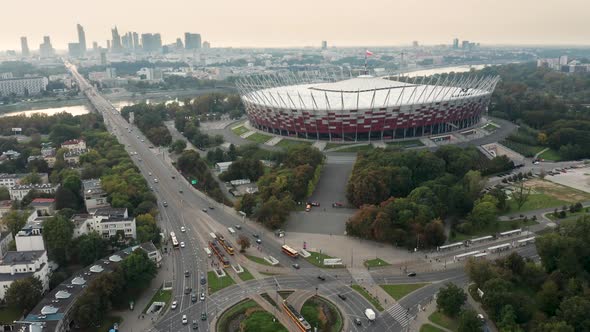 Aerial drone shot of the PGE Narodowy - National Stadium, Warsaw skyline and the Washington Roundabo alt