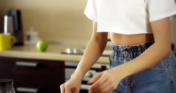 Young Brunette Dancing in a Modern Kitchen Cooking Breakfast