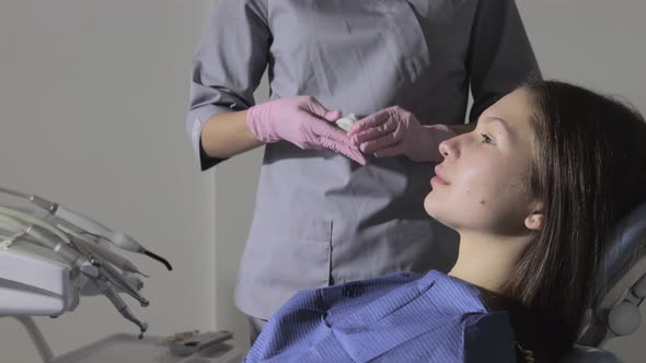The orthodontist using dental impression tray on woman teeth alt