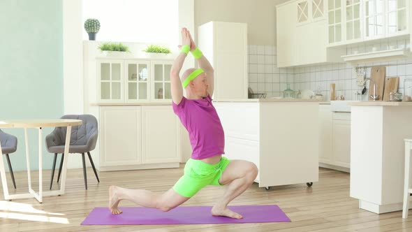 Funny Man Is Doing Yoga Warrior Pose Asana on Mat in Kitchen, Sportive Humor.