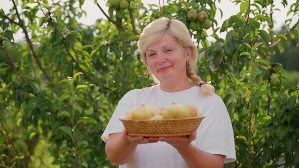 Woman hold in hands basket with onion harvest in garden outdoors. Female farmer with vegetables alt