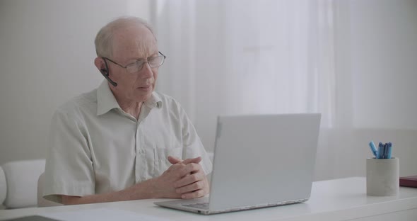 Aged Man Is Using Video Call on Notebook, Sitting at Home, for Communication with Colleagues, Self alt