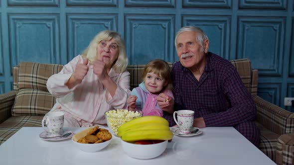 Senior Grandfather and Grandmother Eating Popcorn and Getting Scared Watching Horror Movies at Home alt