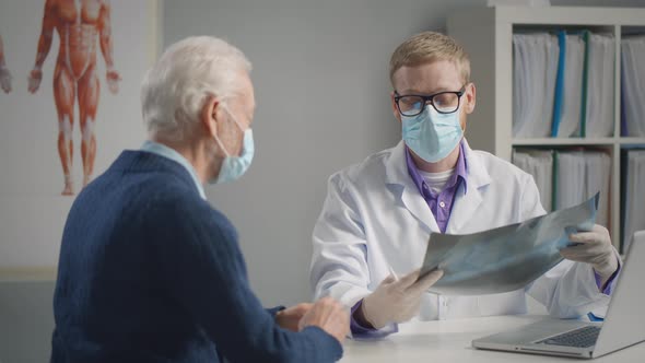 Doctor Consult and Examine X-ray Result with Senior Patient Coronavirus Covid-19 Outbreak alt