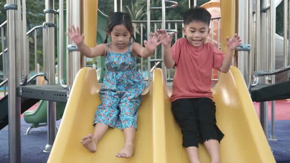 Asian child smiling playing on slider bar toy outdoor playground alt