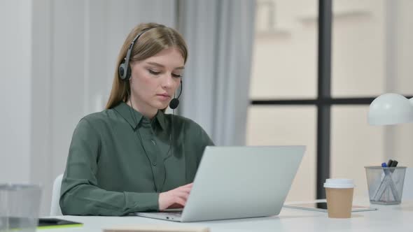 Young Woman with Headset Working on Laptop alt