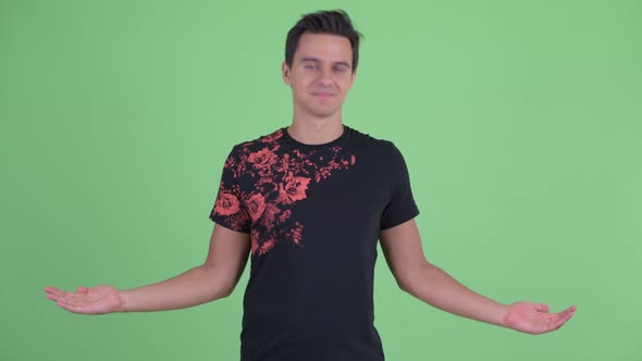 Happy Young Handsome Man Comparing Something alt