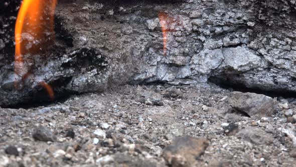 Flame of Methane Underground Emerges From Crack Between Rocks and Burns to Earth alt