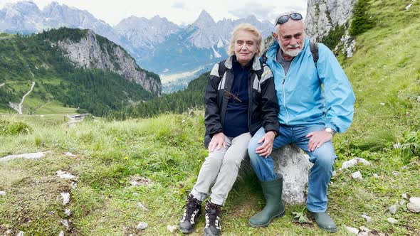 Elderly Couple Relaxing During a Mountain Excursion in the Alps Summer Season alt