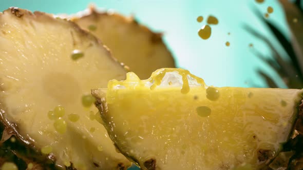 Slow Motion Shot of Pineapple and Juice Splashing Through Pineapple Slices alt