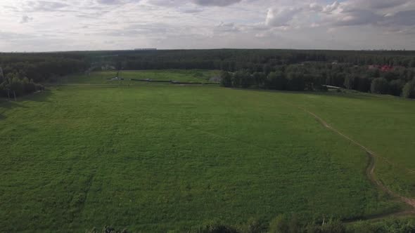 Flying Over Green Field and Rural Road Near the Village, Russia alt