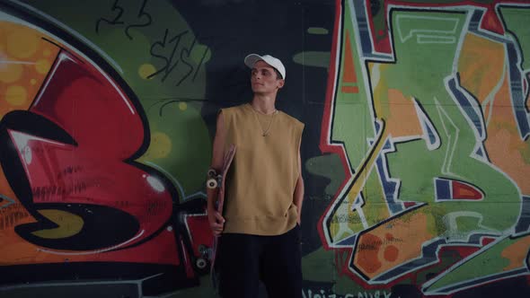 Cheerful Man Having Break After Training at Skatepark alt