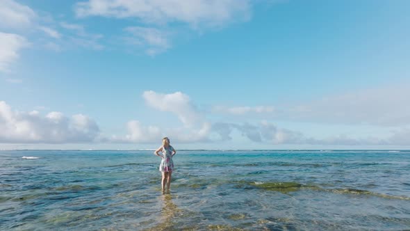 Cinematic Aerial Around Woman in Water with Cinematic Blue Sky Motion Background alt