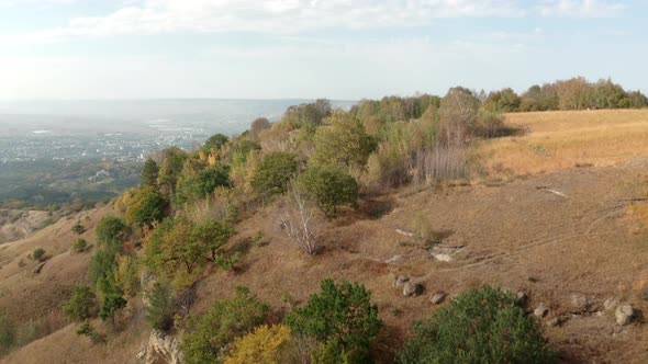 Drone Flying Over Trees and Hills on Cave Mountain Slope with Stunning City View. Natural Mountain alt