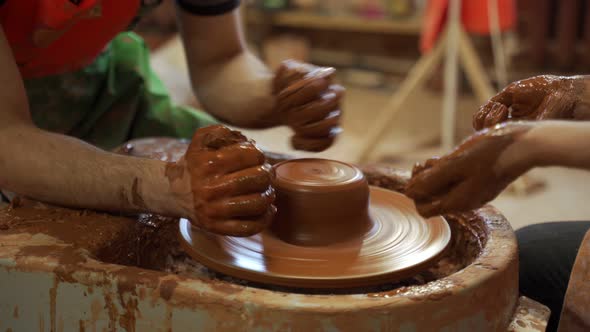 Pottery Training a Closeup of a Man Potter Teaches a Man How to Properly Mold a Bowl of Brown Clay alt