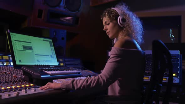 Female sound engineer working at a mixing desk alt