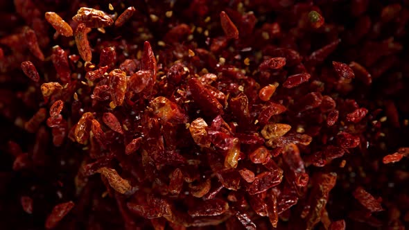 Super Slow Motion Shot of Dried Red Chili Peppers Explosion on Black Background at 1000Fps alt