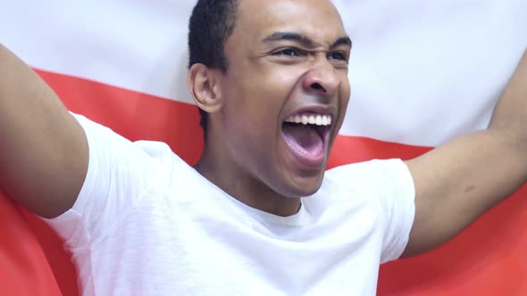 Polish Fan Celebrating while Holding the Flag of Poland alt