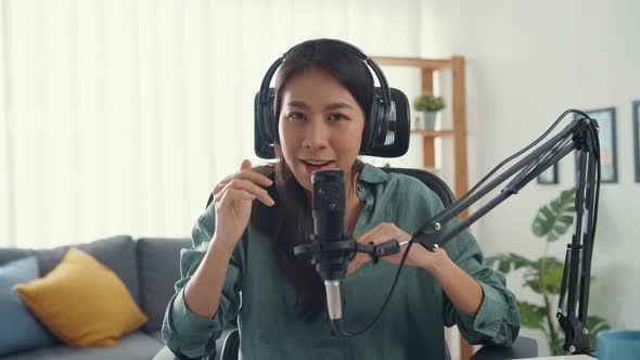 Asia girl record a podcast with headphones and microphone look at camera  talk and take a rest.