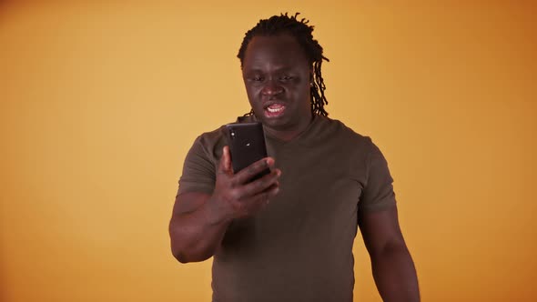 Shocked African American Black Man Reading a Text Message on the Smartphone alt