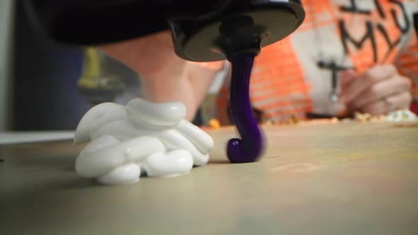 Closeup Shot of Artist Holding Paint Brush and Mix Color on Wooden Palette alt