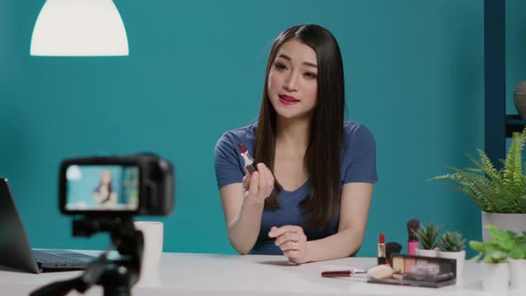 Asian Influencer Reviewing Lipstick Product on Vlogging Camera alt