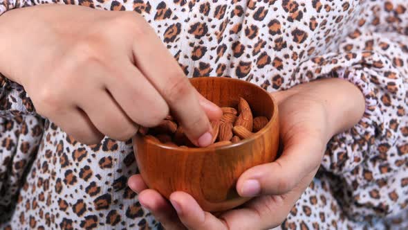 Close Up Women Hand Holding a Bowl on Almond  alt