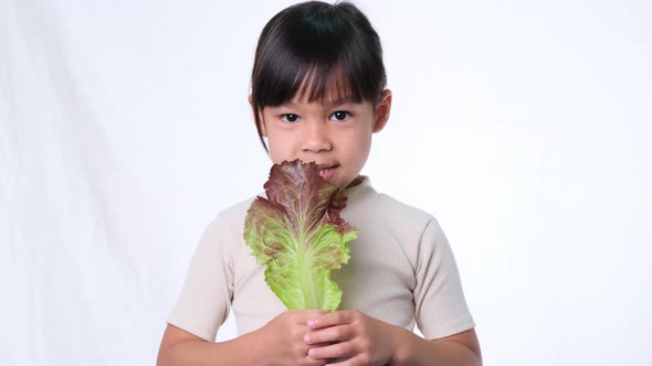 Children do not like to eat vegetables. Little girl who hates eating green salad. alt