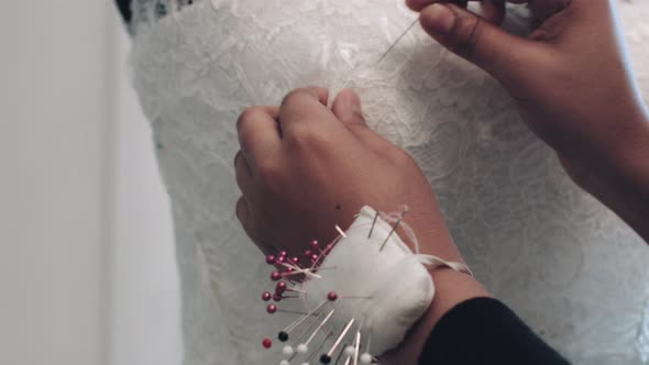 Young entrepreneur pinning wedding dress on Mannequin