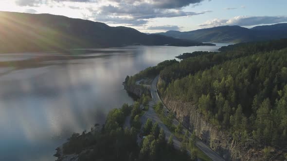 Flying Over Road with Cars and Kroderen Lake Shore in Norway alt