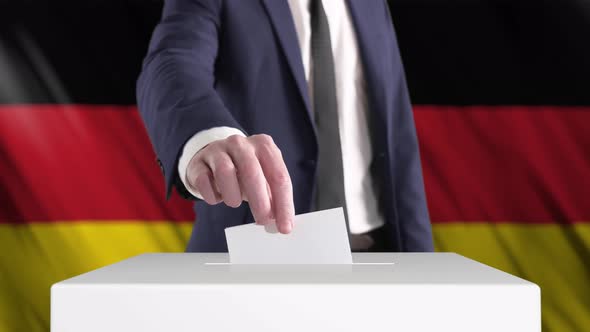 Voting. Man Putting a Ballot into a Voting Box with German Flag on Background.
