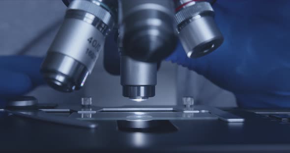 Sample Slide and Microscope with Metal Lens at Laboratory. alt