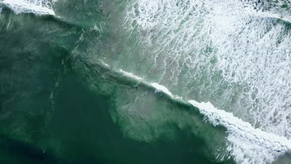 Aerial - Waves rolling out diagonally, beautiful patterns of whitewash and sandy bottom being distur alt