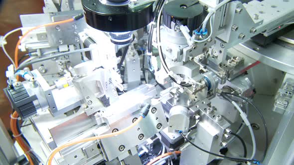 Advanced industrial production line for small parts, robotic arms working alt