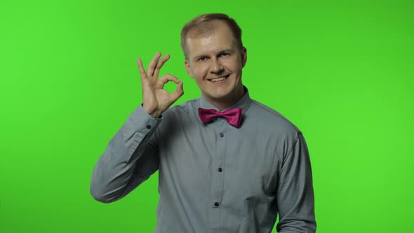 Man Showing Ok Gesture, Smiling with Optimistic Satisfied Expression, Winking, Okay Sign of Approval alt